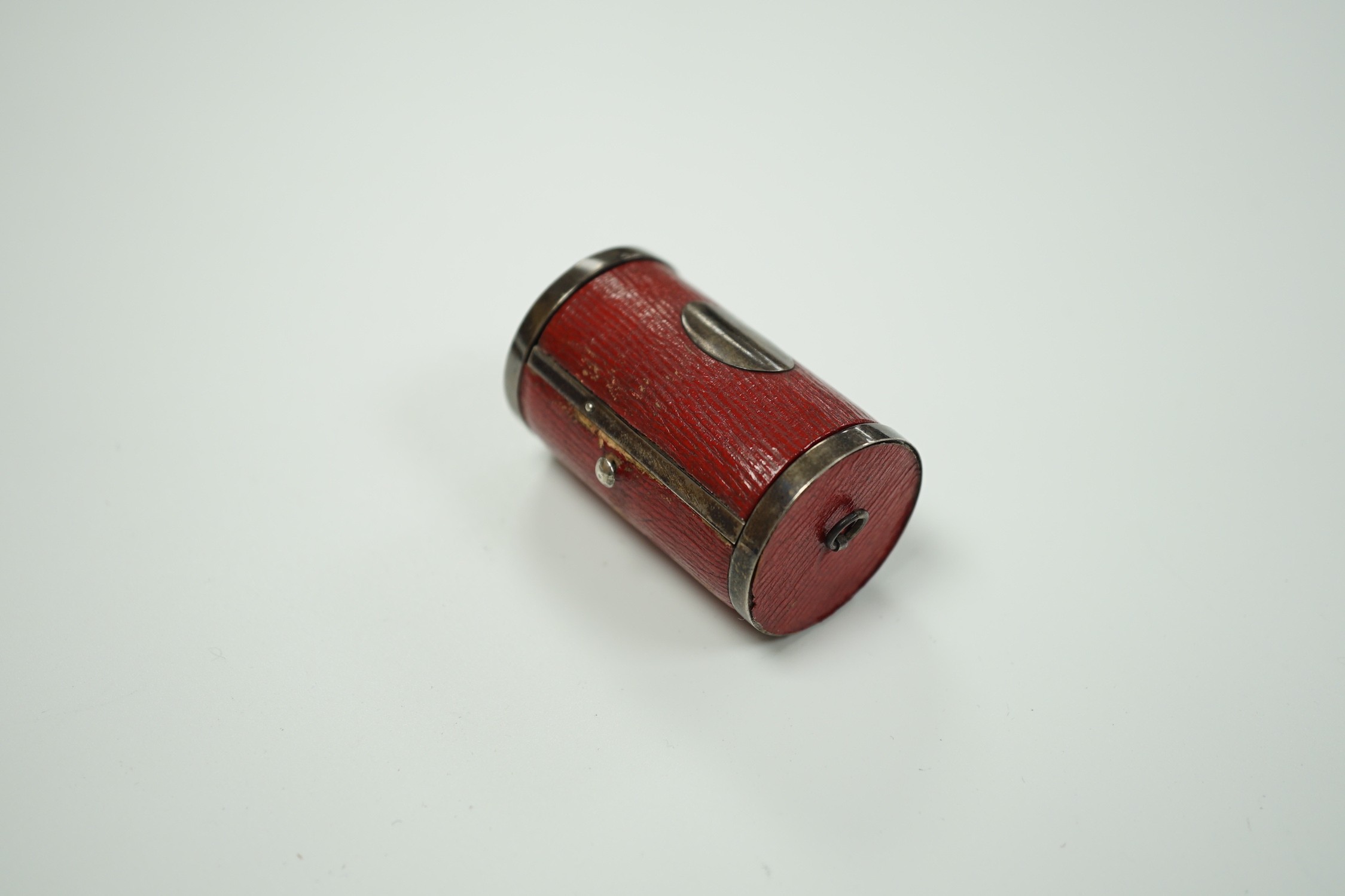 A rare Regency morocco leather mounted white metal cylindrical ring box containing five pinchbeck/base metal sample rings, box length 47mm.
